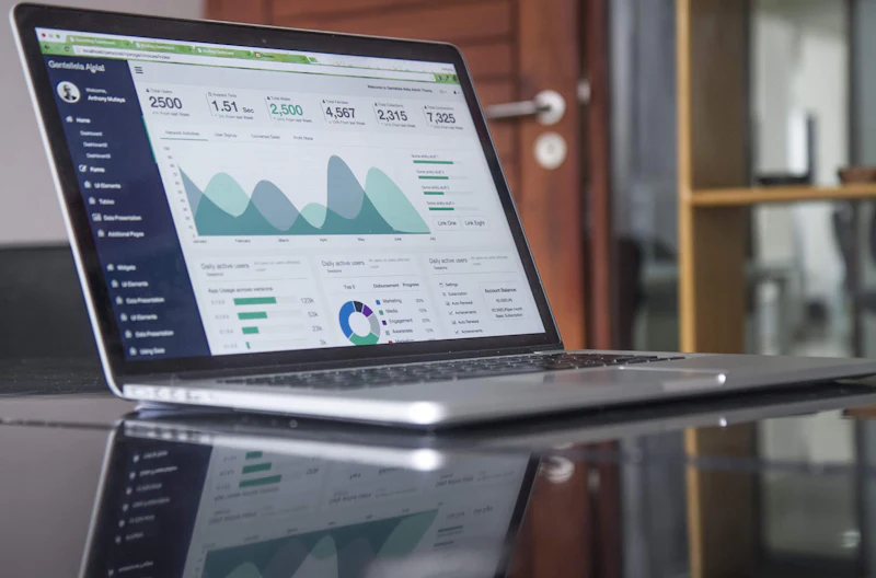 A laptop showing a reporting dashboard with charts and figures