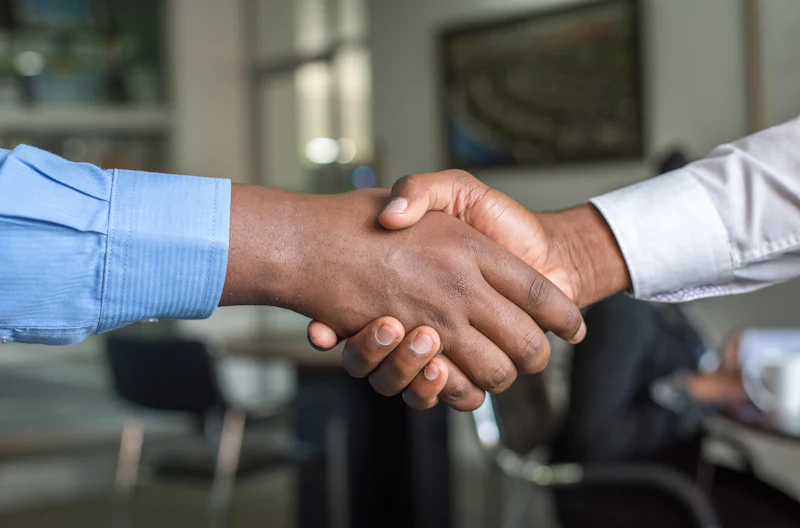 Two people shaking hands to close a business deal