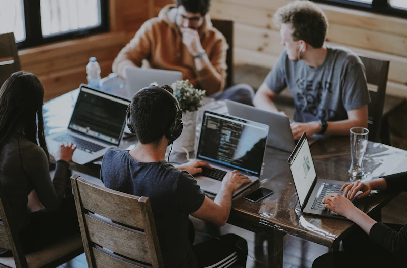 A business team collaborating around a laptop