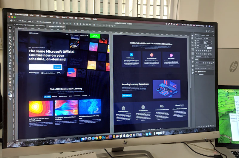 A designer working on a website layout across two screens